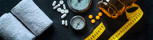 Weight loss supplements, fitness equipment, and time management tools arranged on black background, featuring pills, a measuring tape, hourglass, and nutritional drink.